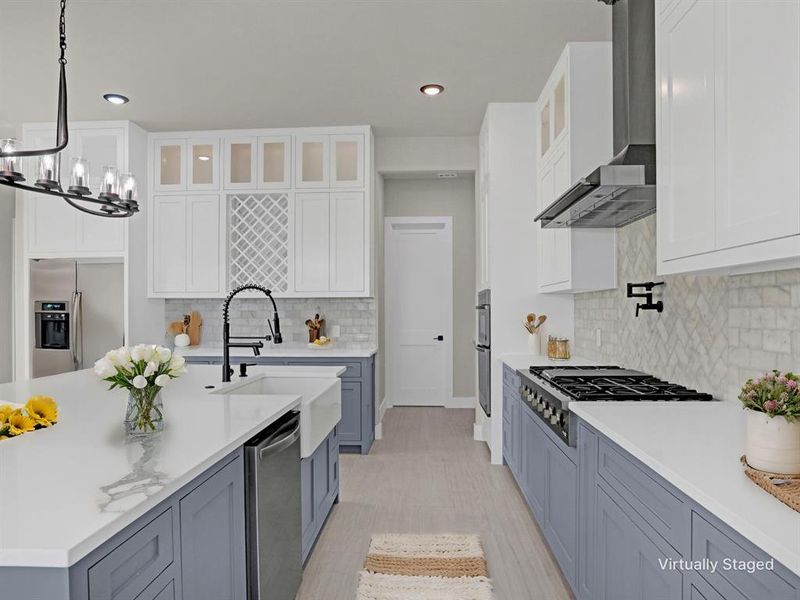 Kitchen with sink, white cabinetry, stainless steel appliances, decorative light fixtures, and wall chimney exhaust hood