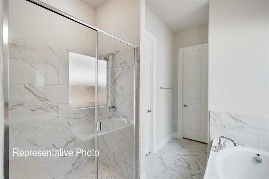 Bathroom with tile flooring and shower with separate bathtub