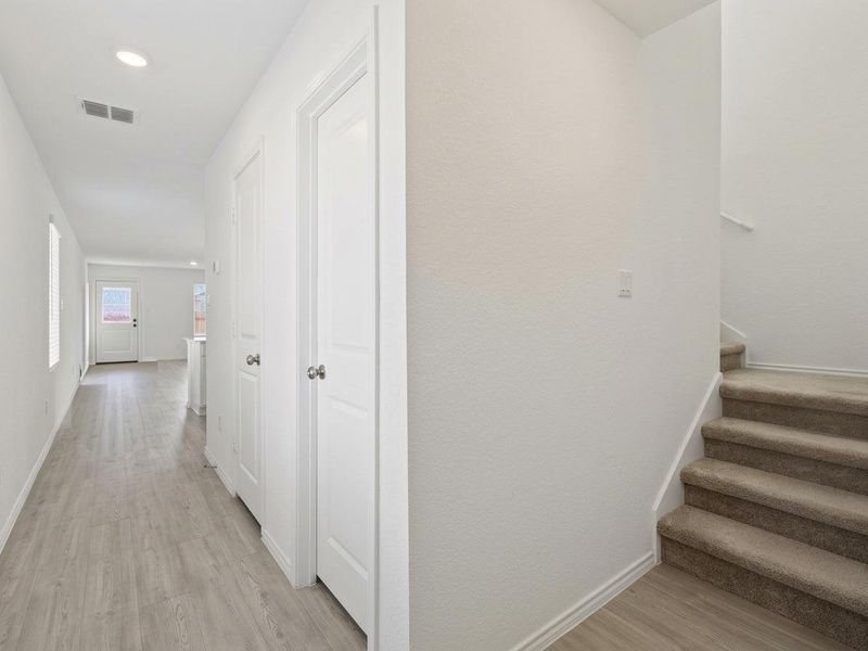 Photo has been enhanced with virtual modifications.  Stairway featuring wood finished floors and recessed lighting