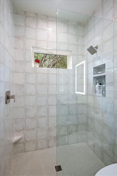 Bathroom with a walk in shower, standing glass shower panel, offset water turn on for convenience