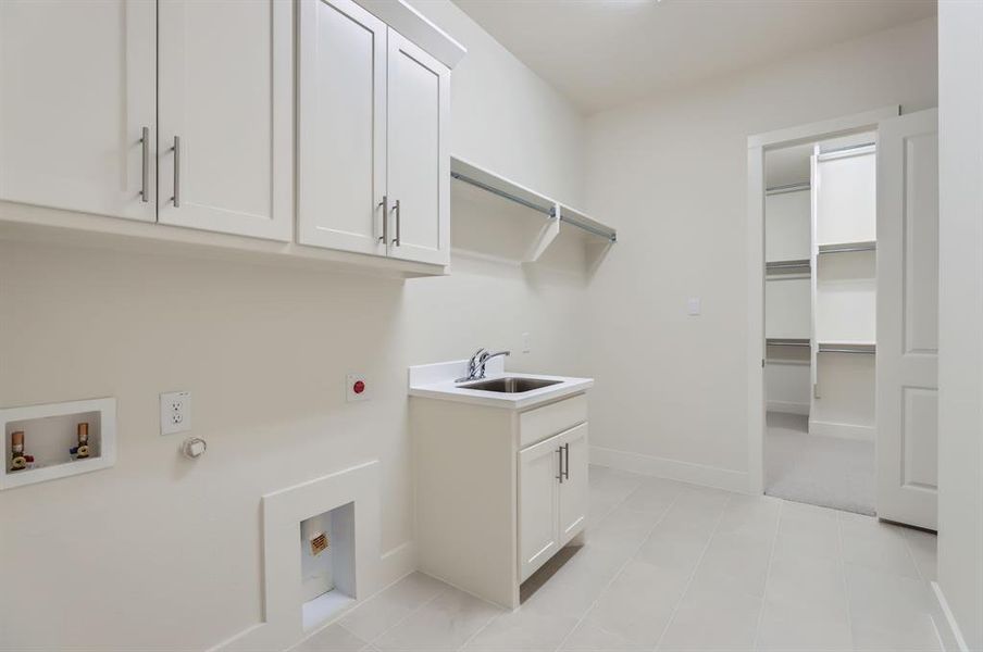 Clothes washing area with hookup for an electric dryer, hookup for a washing machine, cabinets, and sink