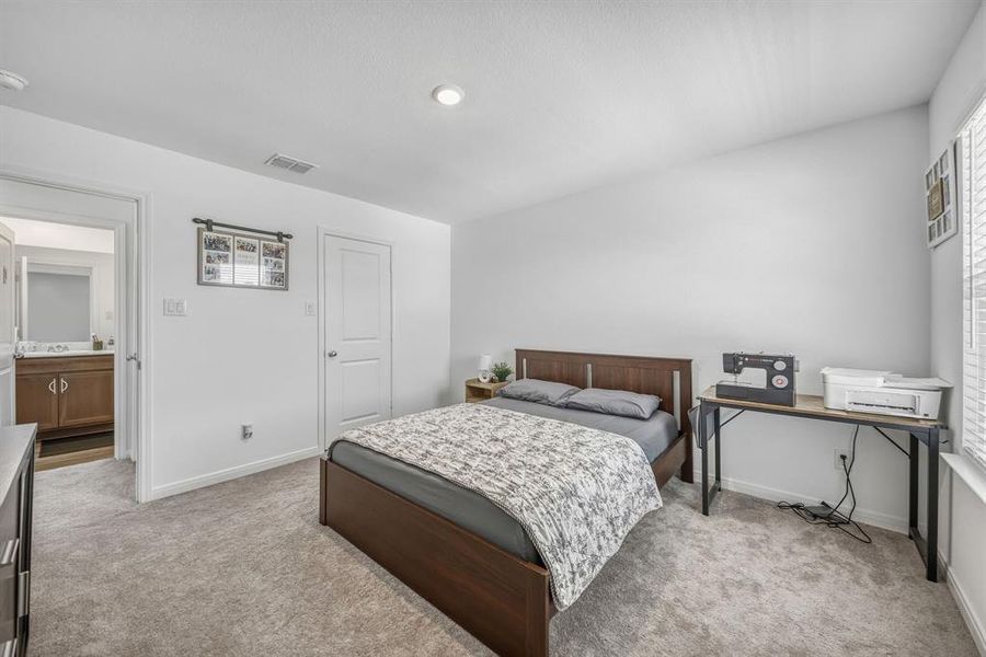 Bedroom featuring neutral-toned carpeting, recessed lighting, and a white interior door Bedroom featuring neutral-toned carpeting, recessed lighting, and a white interior door