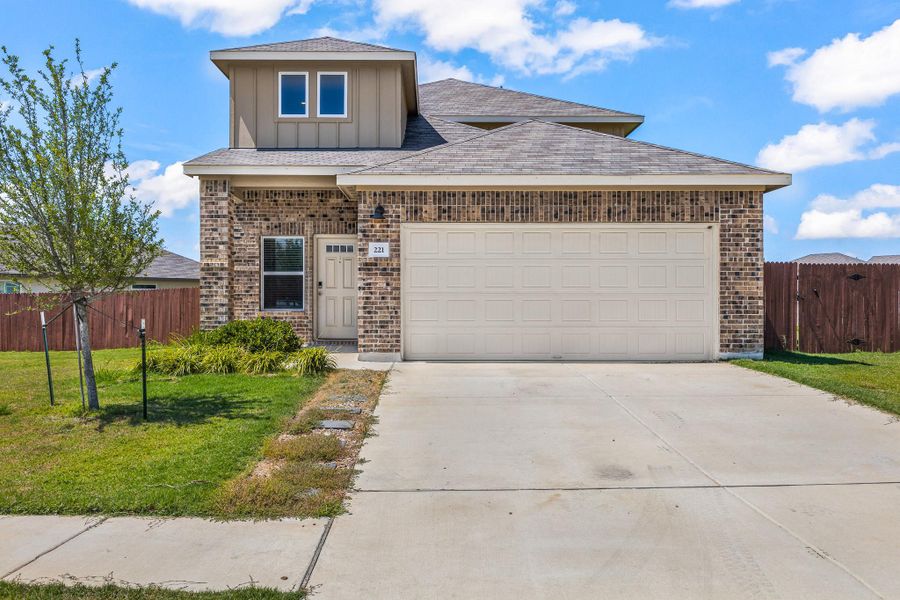 Traditional-style home featuring brick siding, board and batten siding, concrete driveway, and a shingled roof Traditional-style home featuring brick siding, board and batten siding, concrete driveway, and a shingled roof