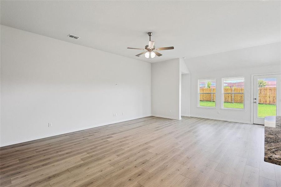 Unfurnished room featuring lofted ceiling, ceiling fan, and light hardwood / wood-style floors