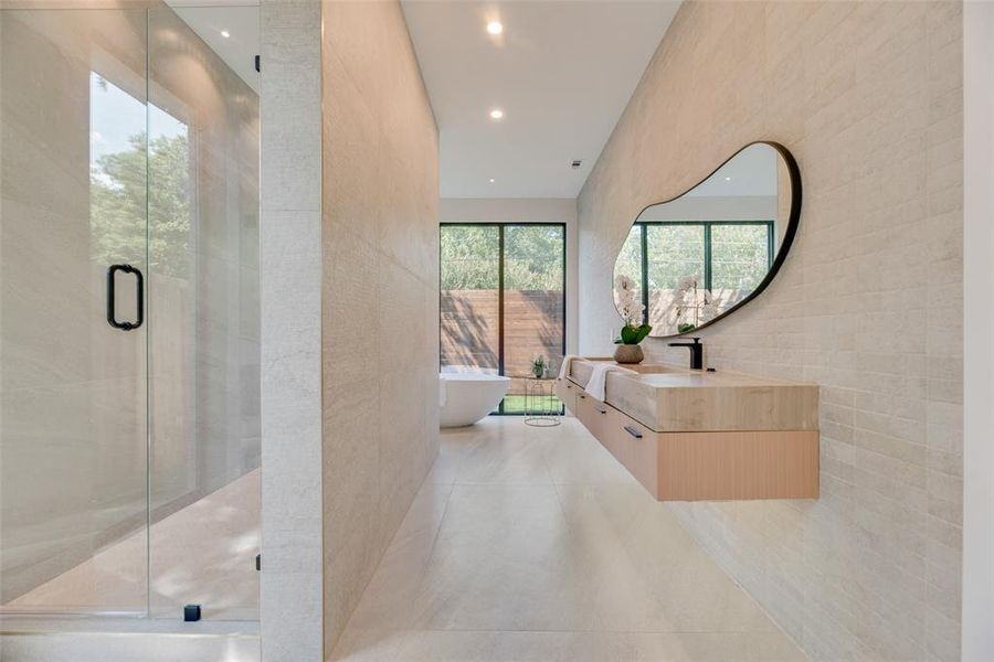 Bathroom featuring vanity, tile walls, plus walk in shower, and tile patterned flooring