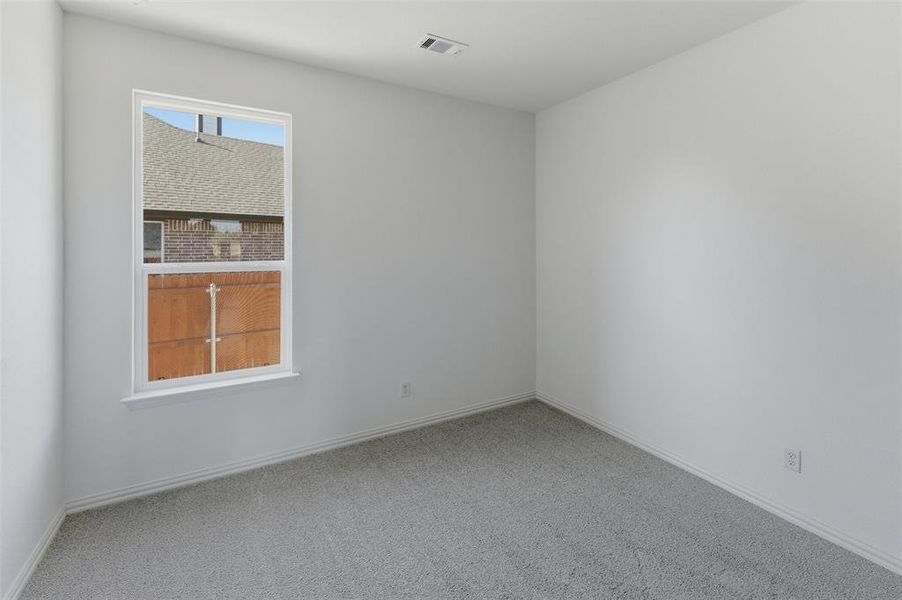 Empty room featuring light carpet and baseboards