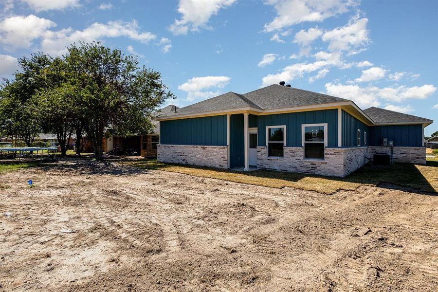 View of side of property featuring board and batten siding and central AC