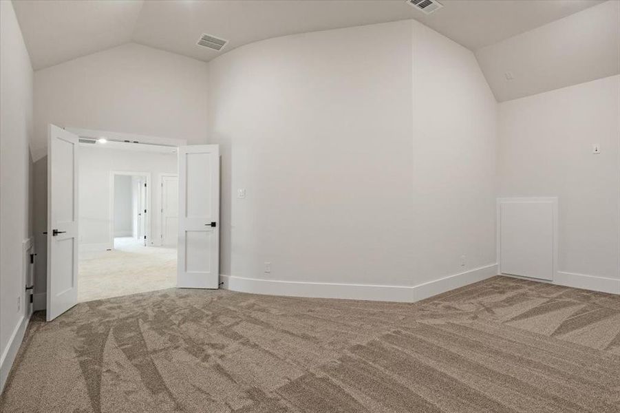 Carpeted empty room with vaulted ceiling