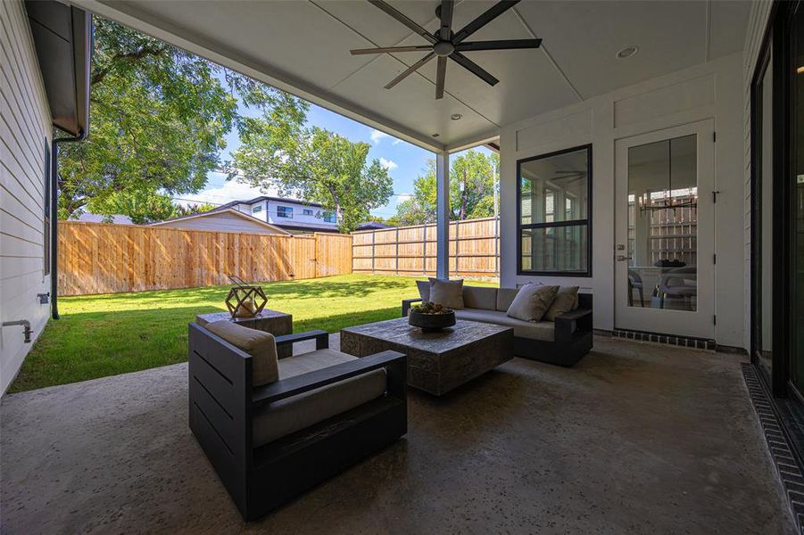 Fenced backyard with an outdoor living space, a ceiling fan, and a patio area Fenced backyard with an outdoor living space, a ceiling fan, and a patio area