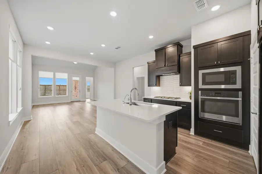 Modern kitchen with quartz countertops, large island, and added outlets beneath countertops. Modern kitchen with quartz countertops, large island, and added outlets beneath countertops.
