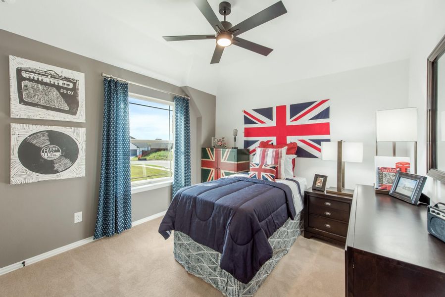 Bedroom with navy bedding, British flag wall decor, ceiling fan, and music-themed artwork on gray walls Bedroom with navy bedding, British flag wall decor, ceiling fan, and music-themed artwork on gray walls