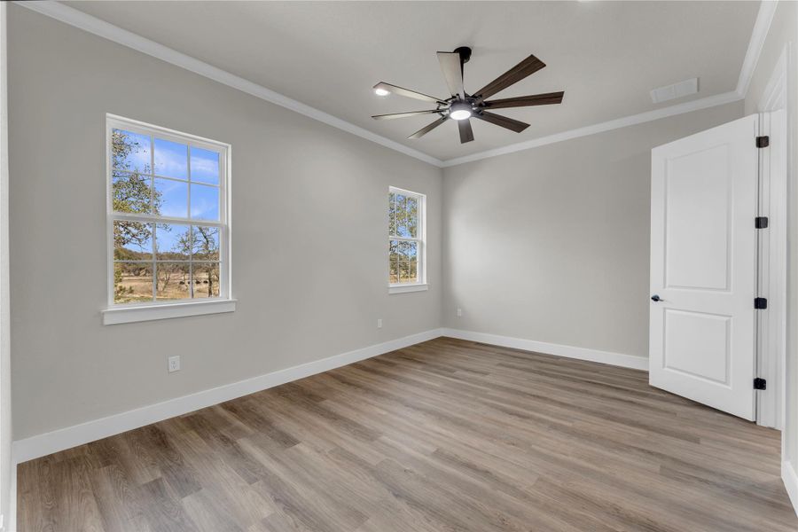 Unfurnished room with light wood-type flooring, crown molding, and ceiling fan