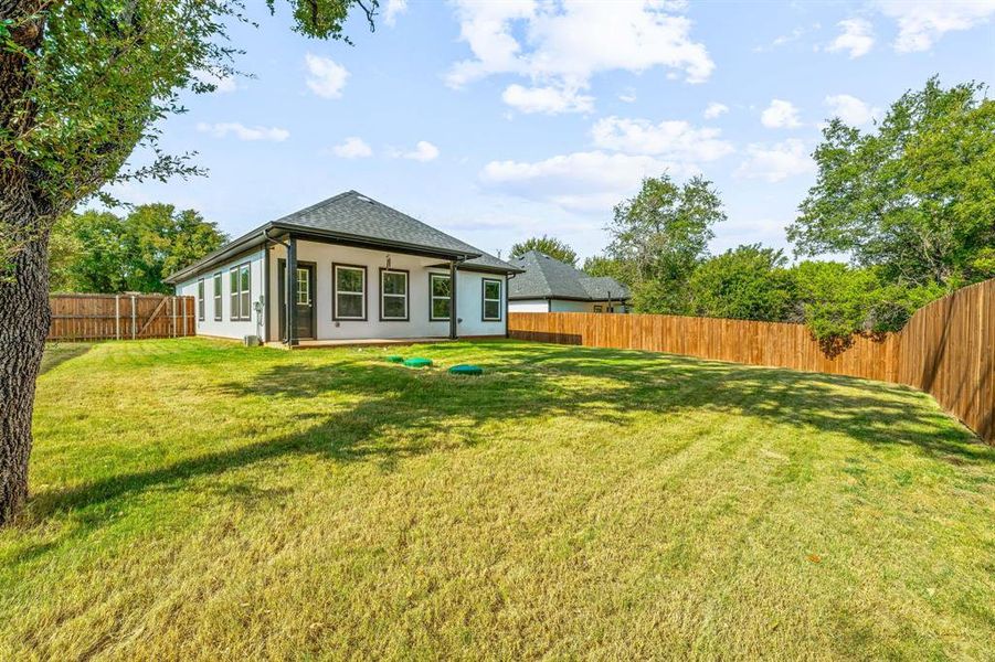 Back of property with a fenced backyard, a patio area, and stucco siding Back of property with a fenced backyard, a patio area, and stucco siding