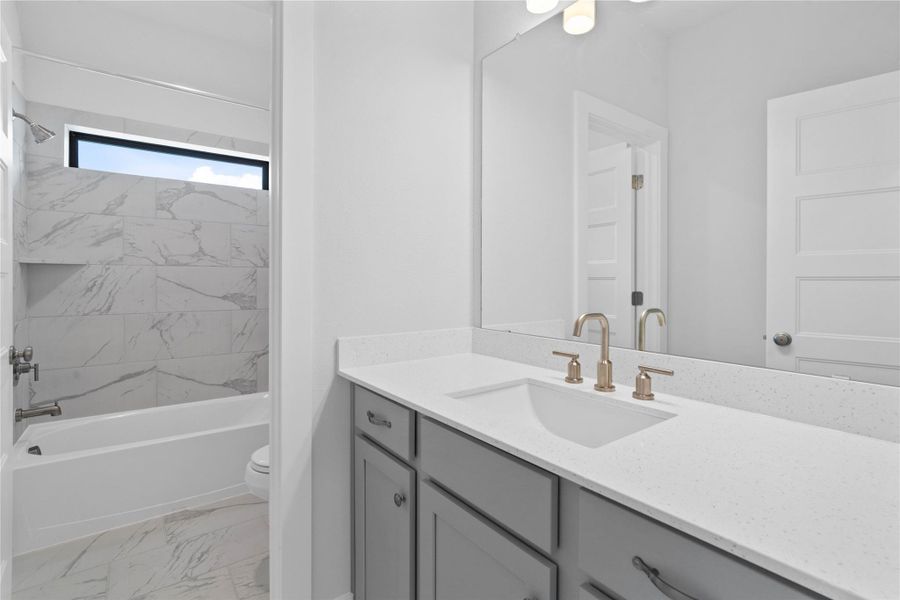 This private vanity area can be closed off - direct access from a secondary bedroom. The tub/shower combination with tile surround and toilet are shared with another secondary bedroom.