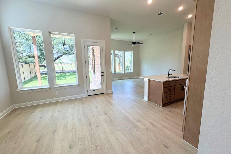 A well-lit open concept living area boasts a kitchen island and plentiful windows for abundant natural light. A well-lit open concept living area boasts a kitchen island and plentiful windows for abundant natural light.
