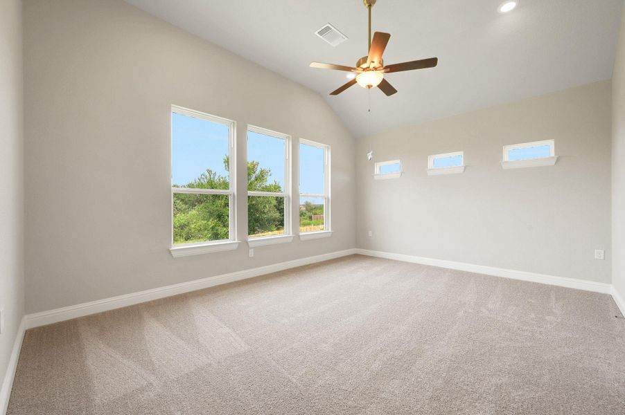 Empty room featuring carpet, vaulted ceiling, and a ceiling fan Empty room featuring carpet, vaulted ceiling, and a ceiling fan