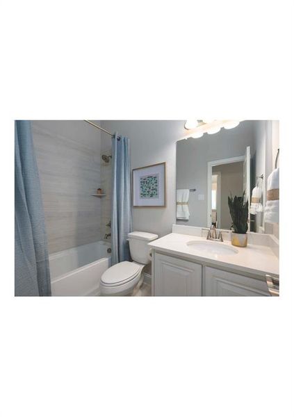 Full bathroom with vanity, shower / tub combo, and toilet