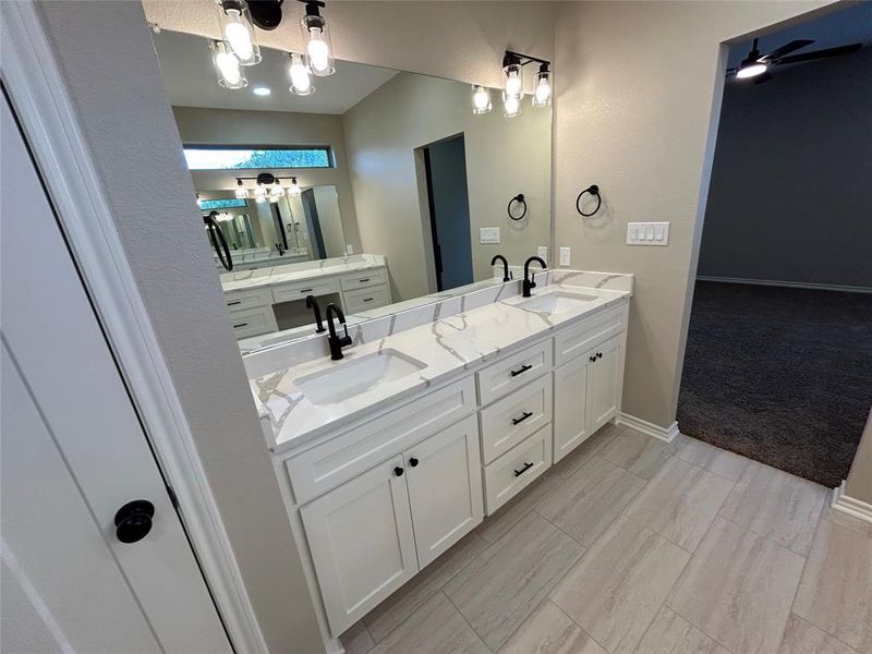 Bathroom with double vanity and a ceiling fan