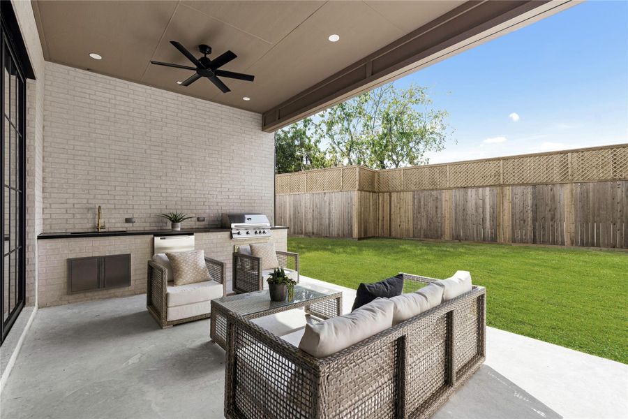 This covered patio is built for entertaining—complete with a sleek outdoor summer kitchen featuring a stainless steel grill, beverage fridge, and gold-tone faucet, all set against a serene mortar wash brick. This covered patio is built for entertaining—complete with a sleek outdoor summer kitchen featuring a stainless steel grill, beverage fridge, and gold-tone faucet, all set against a serene mortar wash brick.