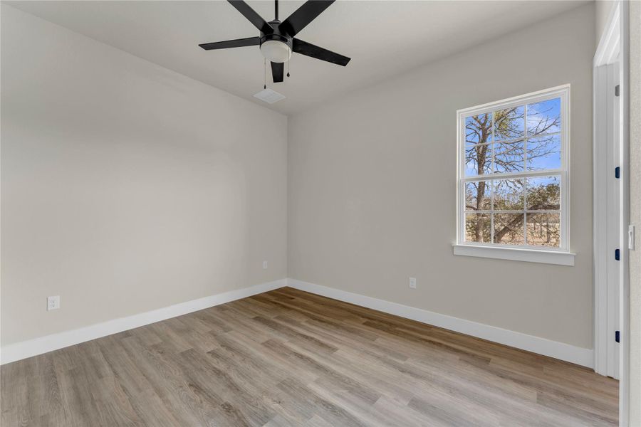 Spare room with light wood finished floors and ceiling fan