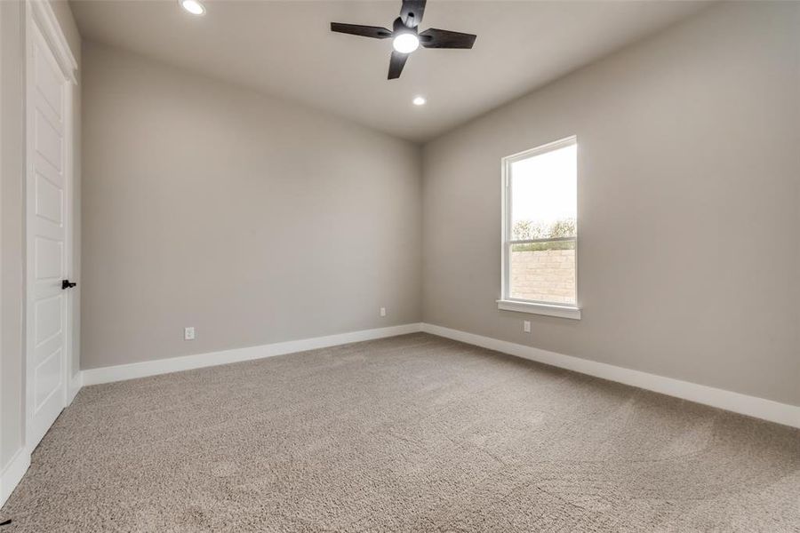 Carpeted empty room with ceiling fan