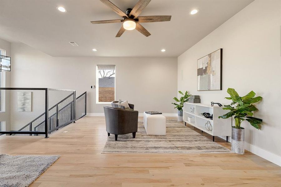 Sitting room featuring light wood-type flooring and ceiling fan