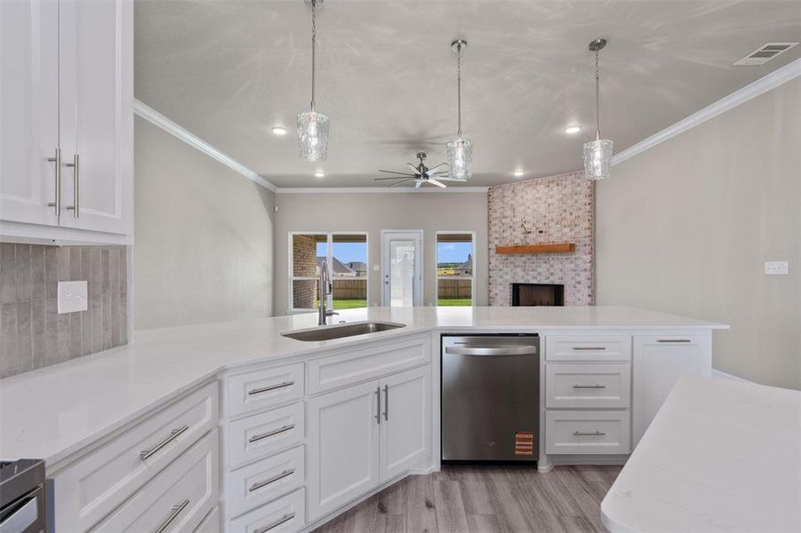 Spacious kitchen featuring white cabinetry, light-toned countertops, and a stainless steel dishwasher Spacious kitchen featuring white cabinetry, light-toned countertops, and a stainless steel dishwasher