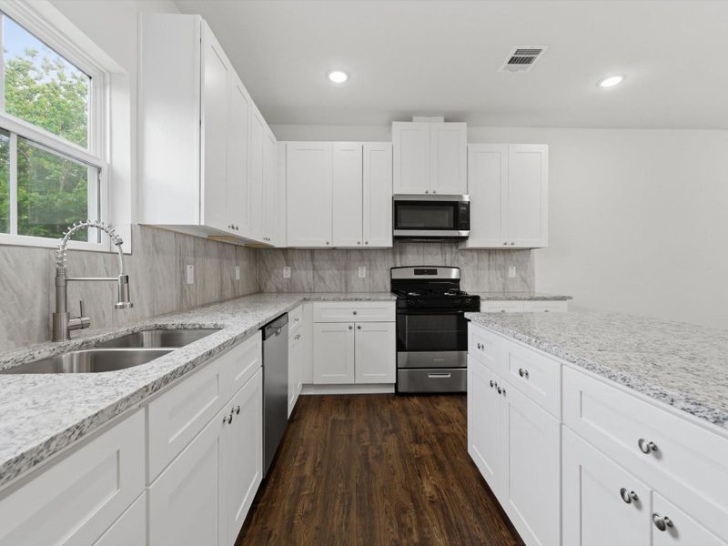 Granite counters, a large center island, self-close cabinets, and abundant storage set the stage for daily culinary adventures.