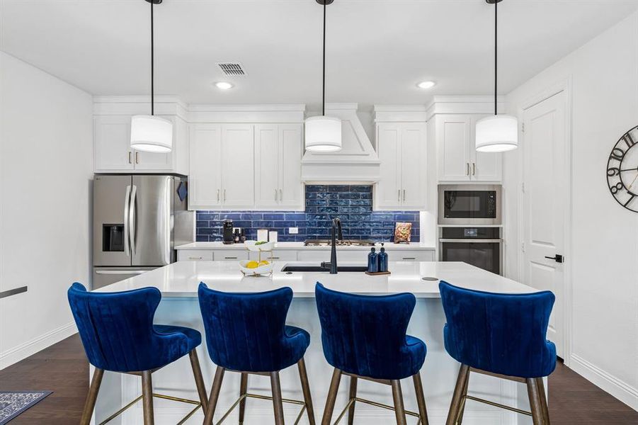 Kitchen
Designed for both everyday living and entertaining, the kitchen showcases crisp cabinetry, quartz surfaces, a large island, and striking designer finishes.