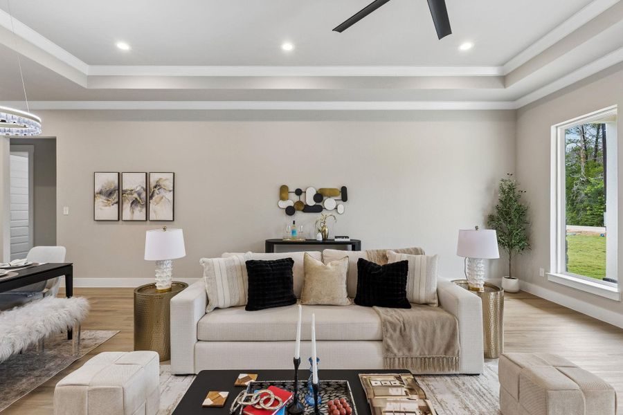 An inviting gathering space features an open floorplan with recessed lighting and warm wood flooring.