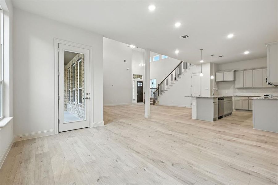Unfurnished living room featuring stairway, light wood-style floors, and recessed lighting