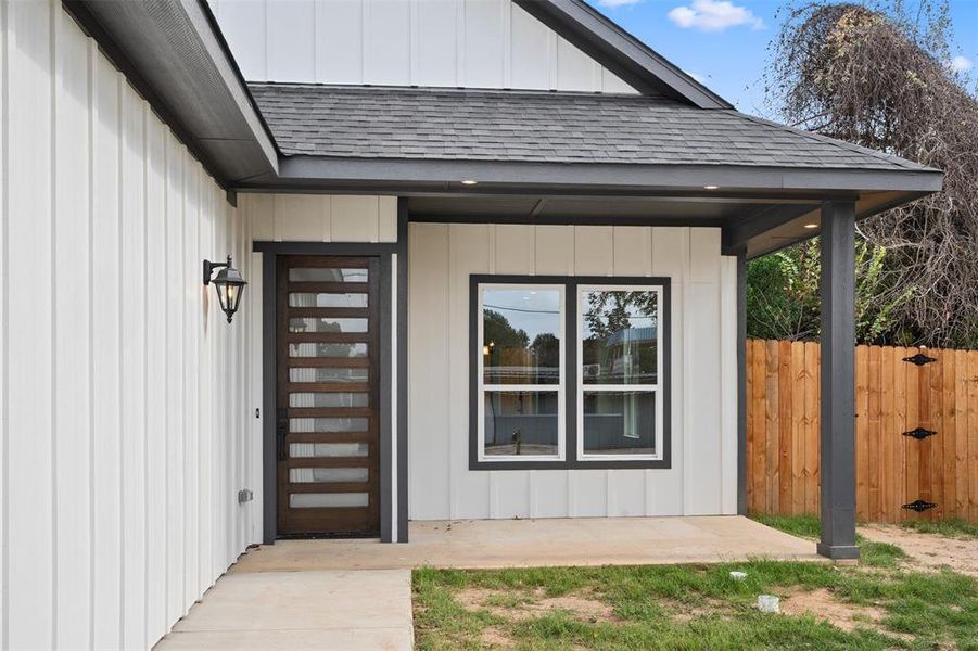 Doorway to property featuring a shingled roof Doorway to property featuring a shingled roof