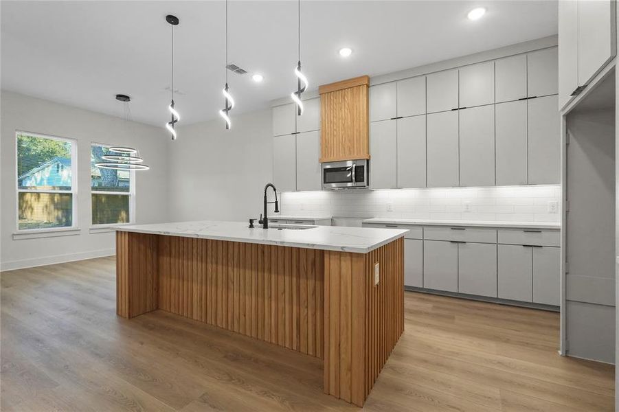 Kitchen with white cabinetry, brown cabinets, modern cabinets, decorative backsplash, and light wood-type flooring