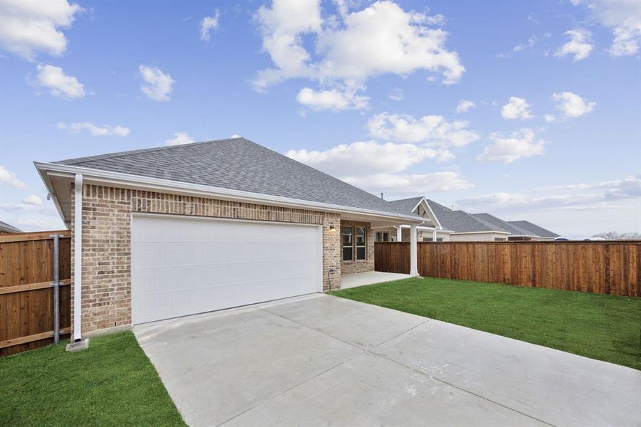 View of front of home with a garage and a front lawn