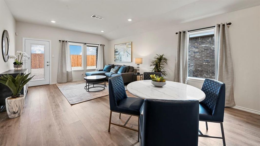 Dining space featuring light wood-style floors, recessed lighting, and lofted ceiling Dining space featuring light wood-style floors, recessed lighting, and lofted ceiling