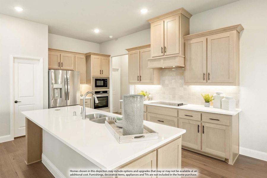 Kitchen with light beige cabinets, large center island, white countertops, and stainless steel appliances on hardwood floors