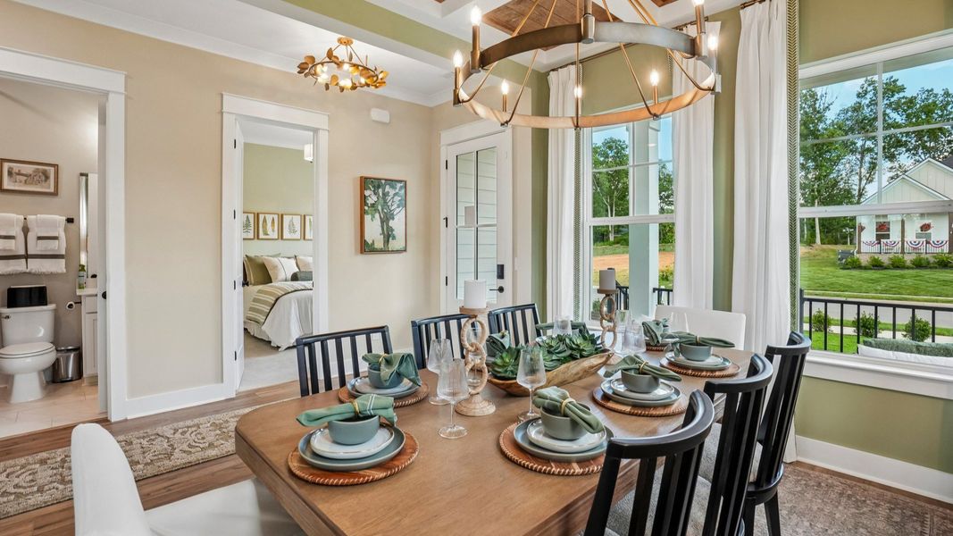 Dedicated dining area with coffered ceiling, natural lighting from windows, and access to front entry Dedicated dining area with coffered ceiling, natural lighting from windows, and access to front entry
