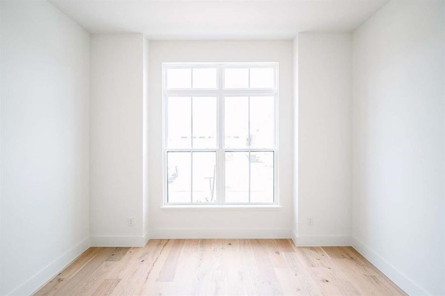 Unfurnished room with light wood-type flooring and a wealth of natural light