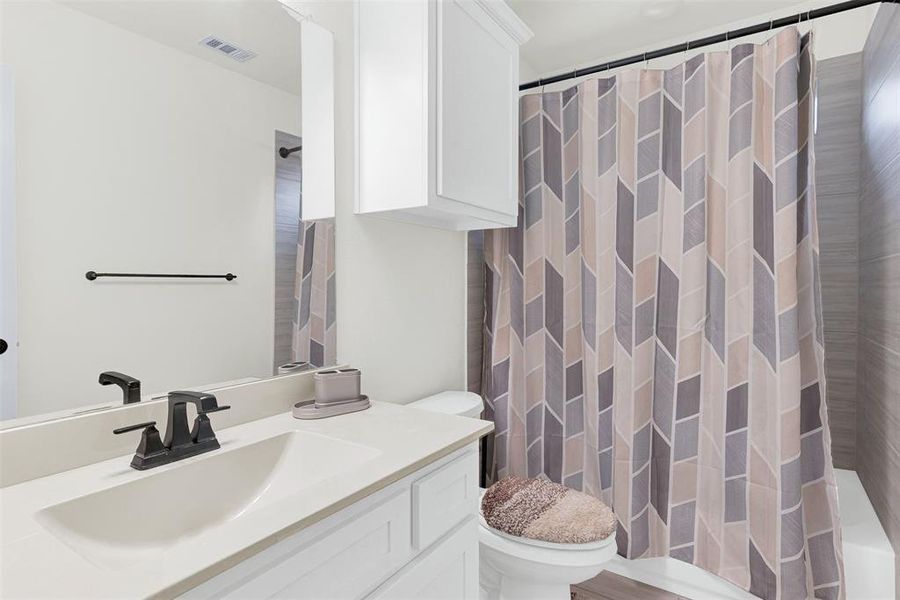 Bathroom featuring vanity and shower / bath combo with shower curtain Bathroom featuring vanity and shower / bath combo with shower curtain