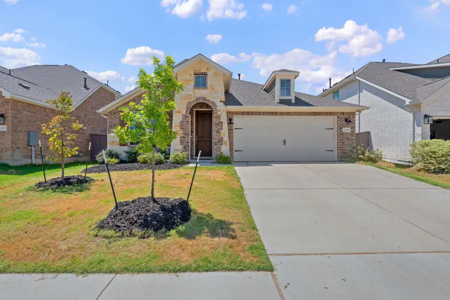View of front of property featuring stone siding, concrete driveway, roof with shingles, brick siding, and an attached garage View of front of property featuring stone siding, concrete driveway, roof with shingles, brick siding, and an attached garage