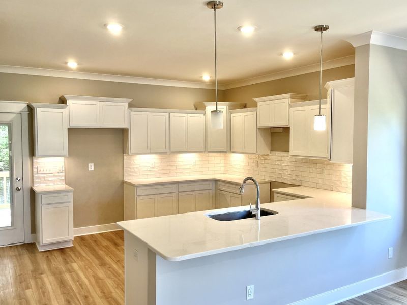 Stock photo Lots of room in kitchen to cook or gather. Undercabinet lights sparkle on textured backsplash