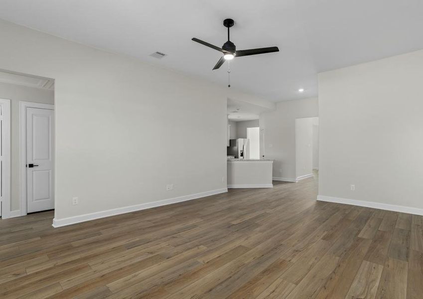 Spacious family room with plank flooring and a ceiling fan