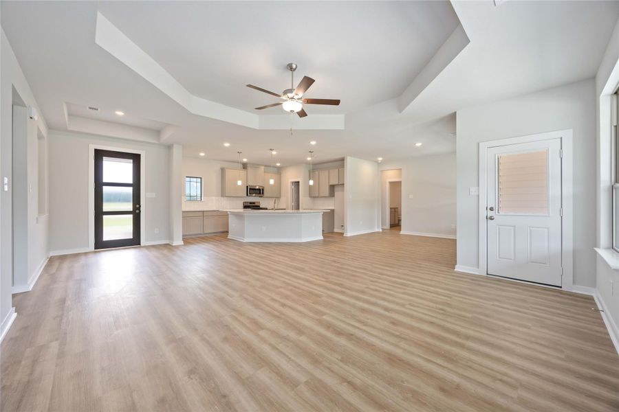 Light-filled family room with warm-toned flooring and seamless flow into the kitchen and dining areas. Light-filled family room with warm-toned flooring and seamless flow into the kitchen and dining areas.