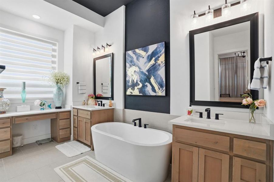 Full bathroom featuring a freestanding tub, light tile patterned flooring, and two vanities Full bathroom featuring a freestanding tub, light tile patterned flooring, and two vanities