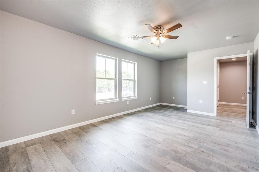 Unfurnished bedroom with ceiling fan and light wood-type flooring