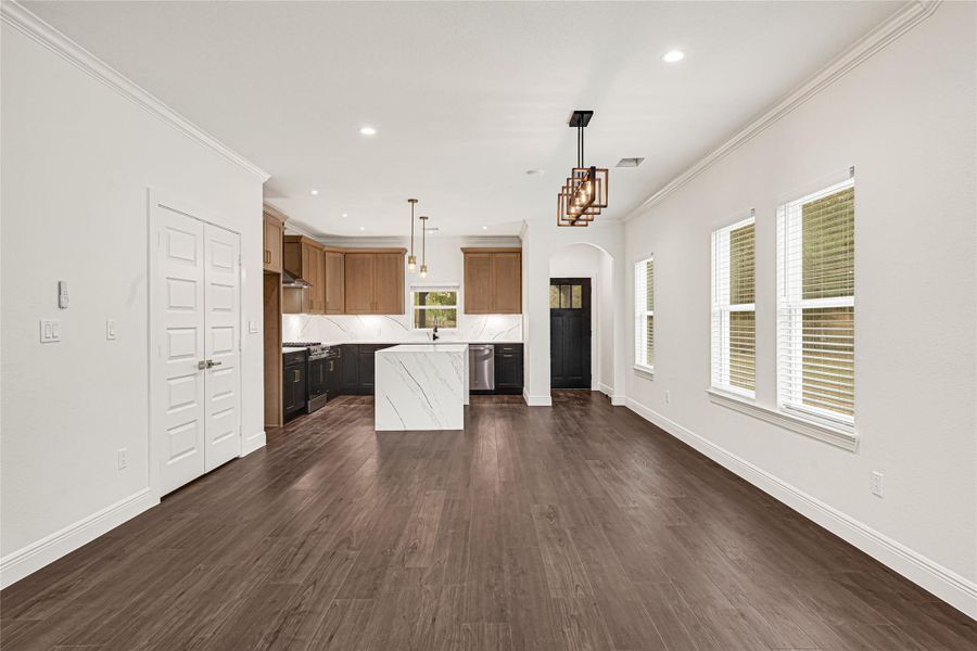 This photo showcases a modern, open-concept kitchen and dining area with dark wood floors, white walls, and ample natural light. The kitchen features an island with a marble design, pendant lighting, and sleek cabinetry, creating a stylish and functional space. This photo showcases a modern, open-concept kitchen and dining area with dark wood floors, white walls, and ample natural light. The kitchen features an island with a marble design, pendant lighting, and sleek cabinetry, creating a stylish and functional space.