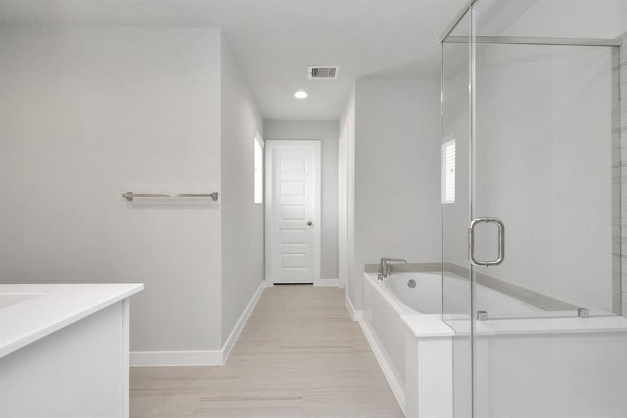 Step into a sanctuary of relaxation in your primary bathroom. Revel in the expansive walk-in shower surrounded by tasteful tile, unwind in a separate garden tub adorned with personalized detailing.