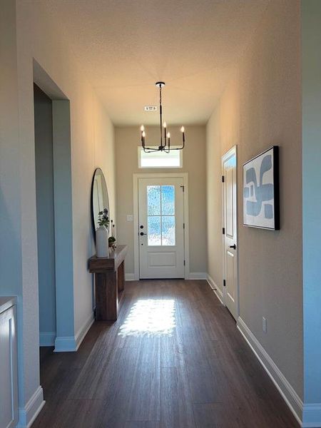 Foyer featuring a chandelier and dark wood-style floors