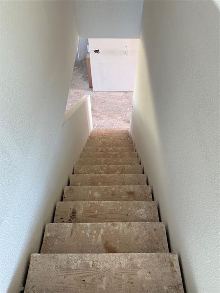 Stairway featuring a textured wall