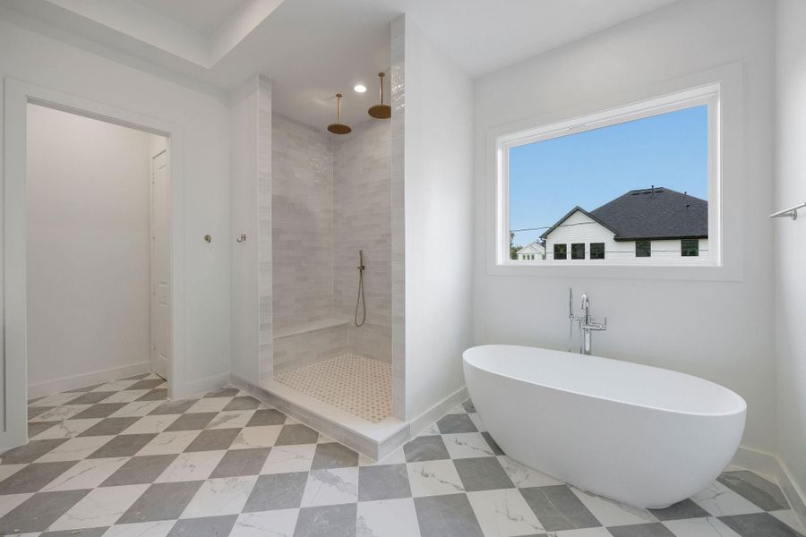 The elegant primary bathroom offers a large shower, soaking tub, double sinks, and private WC. The elegant primary bathroom offers a large shower, soaking tub, double sinks, and private WC.